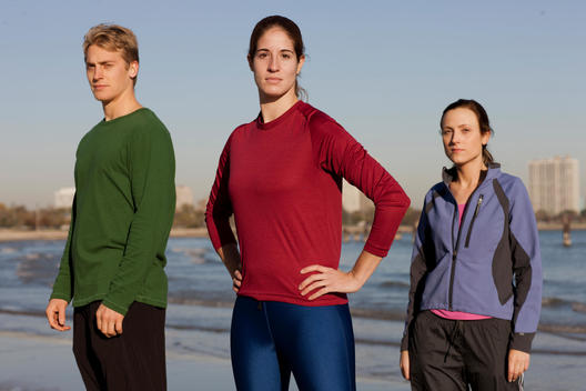 Three Runners Pose On A Chicago Beach Next To Lake Michigan.