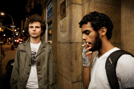 Two Young Men Standing On The Street In The Night.