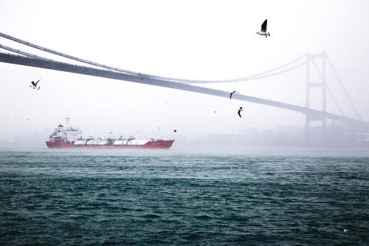 Commercial vessel is passing under Bosphrous Brdige during the fogy and snowy day of Istanbul?s new year eve.