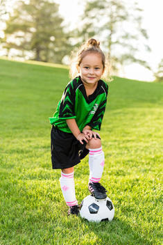 Little girl in Soccer uniform on ball