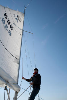 Man Adjusting Rigging On Sailboat