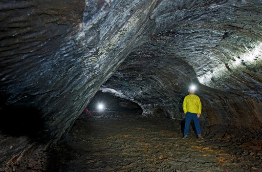 Man in Leidarendi cave lava tube, Tvibollahraun lavafield, Hafnarfjordur, Reykjavik, Iceland
