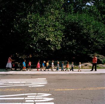 School Children Are Linked Together Along The Sidewalk With Teachers At Either End.