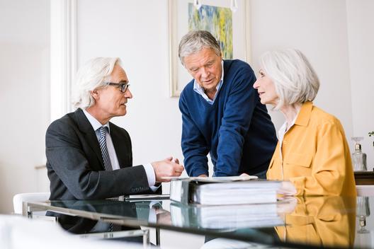 Senior adults in business meeting discussing paperwork