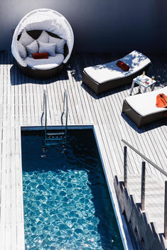 Lounge chairs on wooden deck near lap pool