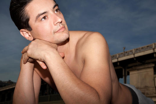 Young athletic man resting on his stomach, in urban setting