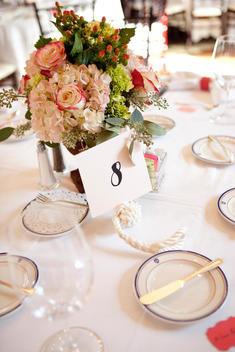 Table setting at a wedding, centerpiece with roses and name cards