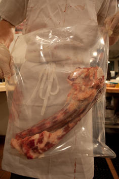 Butcher Holding A Block Of Meat In A Plastic Bag