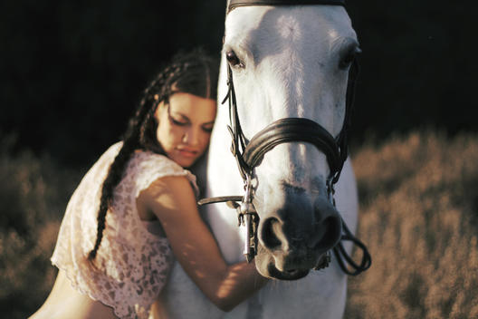 Young Woman Hugging White Horse