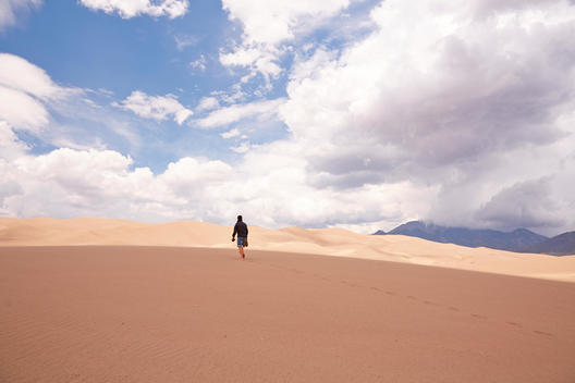 a man walking in he great sand dunes