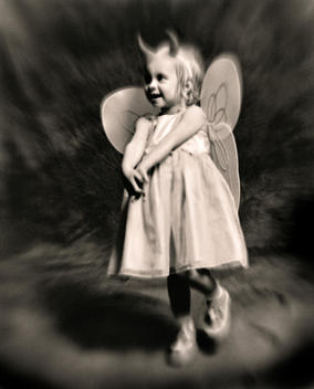 Young girl wearing devil horns and angel wings