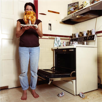 Woman Holding Cooked Chicken On A Strange Contraption