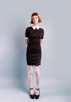 Portrait of Young woman in black dress. Short hair, dress is old style look.