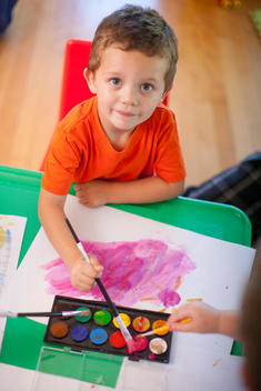 Portrait of boy painting at nursery school