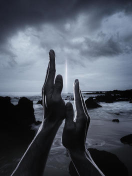 Two Hands Framing Light Effect Over Dramatic Seascape.
