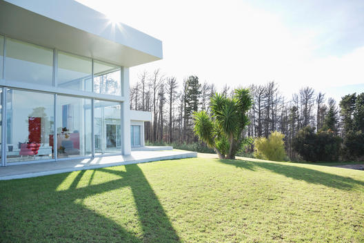 Modern house casting shadows on manicured lawn