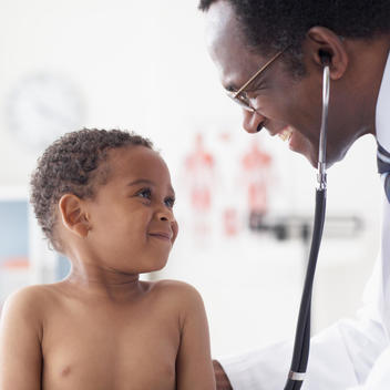 African male doctor examining african boy