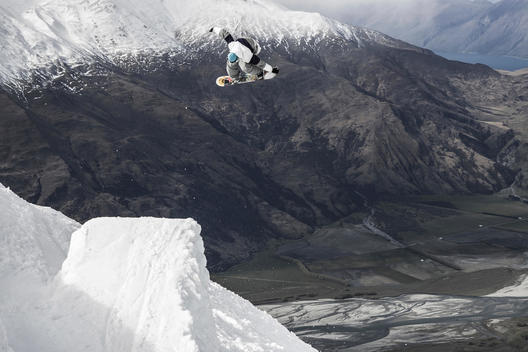 Snowboarder spins off backcountry jump