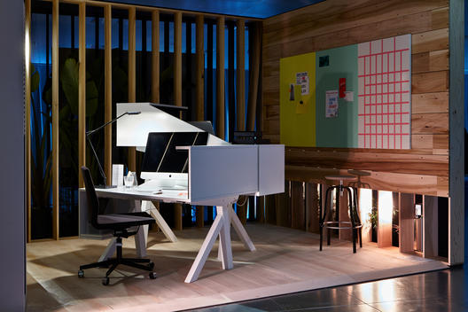 Modern graphic office with Mac, slatted wall and graphic design work upon board