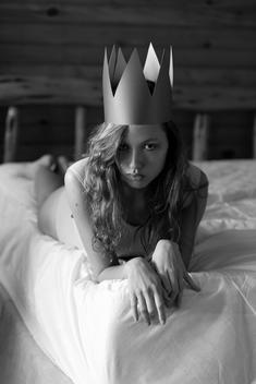 Young Woman On Mattress With Crown