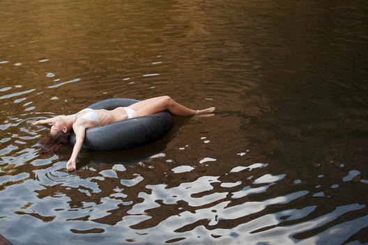 Woman floating in inner tube in river