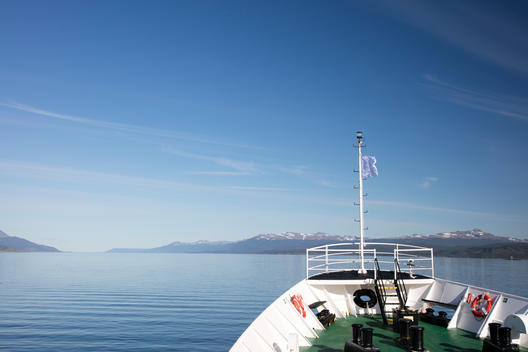 An expedition tourist ship departs through the Beagle Channel in Argentina en route to Antarctica. Logos removed.