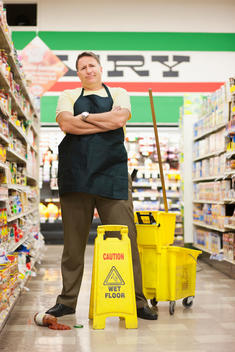 Caucasian man cleaning up spill in grocery store