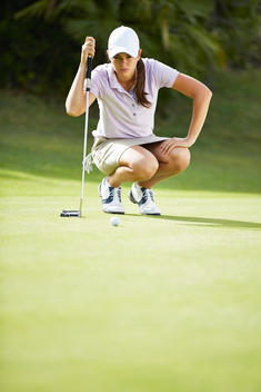 Woman preparing to putt on golf course