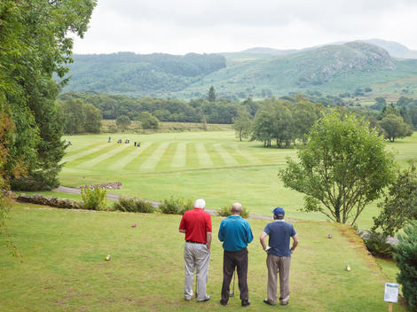 A group of men tee-off on the first hole of Eskdale Golf Course, which is set in the majestic Eskdale Valley of the Lake District.