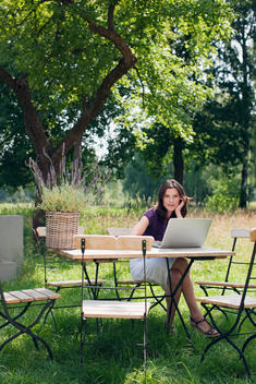 Germany, Hamburg, Woman using laptop in garden