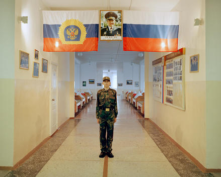 A Young Russian Student In Army Attire Poses Under A Portrait Of A Military Leader And Russian Flag At The Krasnoyarsk Military Cadet School In Eastern Siberia.