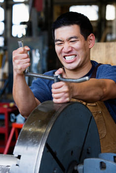 Asian man working with metal in warehouse