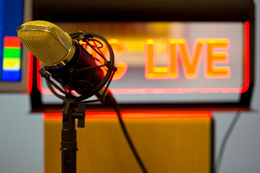 Close up of a gold microphone and illuminated sign