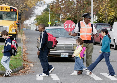 Children crossing street with crossing guard