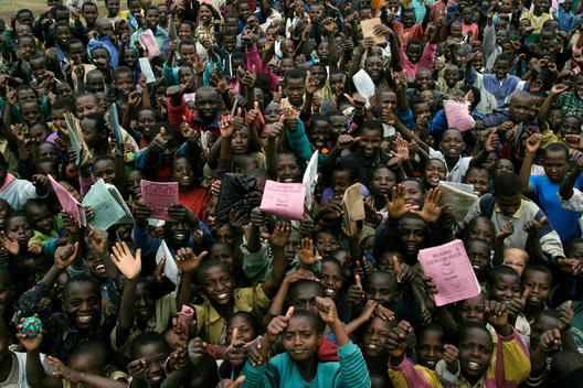 Hundreds of young students wave their exercise books at a school in Ruhengeri, Rwanda, East Africa.