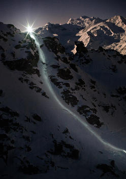skiers creating lines with torches on their helmets nighttime skiing