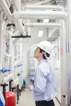 Engineer checking equipment in operation at industrial plant