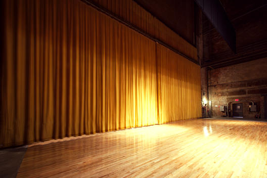 Backstage View Of Large Stage With Curtain Drawn -- Giant Yellow Curtain And Wood Stage