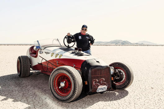 A man poses with his show car on El Mirage dry lake bed in California
