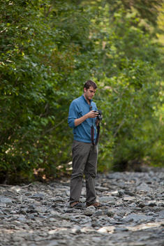 A Man Takes Pictures Of A Riverbed In Seward, Alaska.