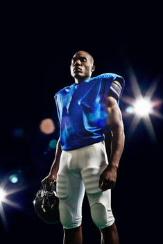 Portrait of american football player holding helmet