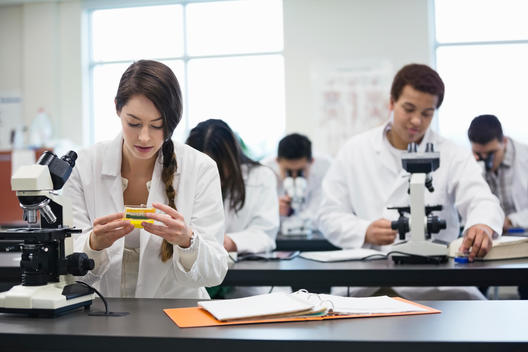 Students with microscopes in science lab at college campus