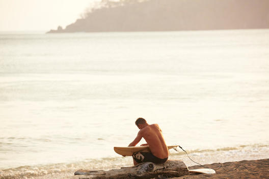 A man waxing his surfboard