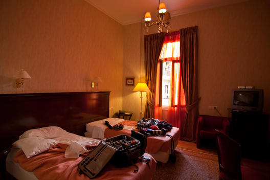 Hotel Room With Suitcases On Unmade Beds, Nafplion, Greece.