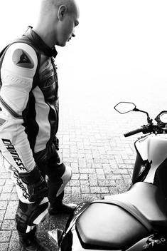 A motorcycle rider standing next to his motorcycle