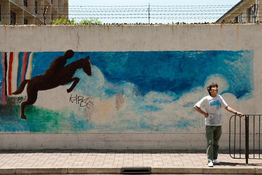 mural painting in the street, a man standing on the sidewalk