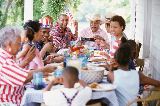Multi-generation Black family eating at Fourth of July barbecue