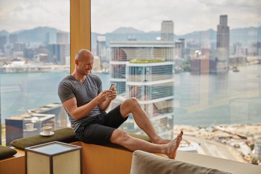 Man texting in window of The Upper House hotel, Hong Kong