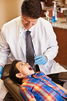 Dentist examining patient\'s teeth