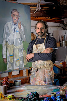 Portrait of an artist next to a recent work